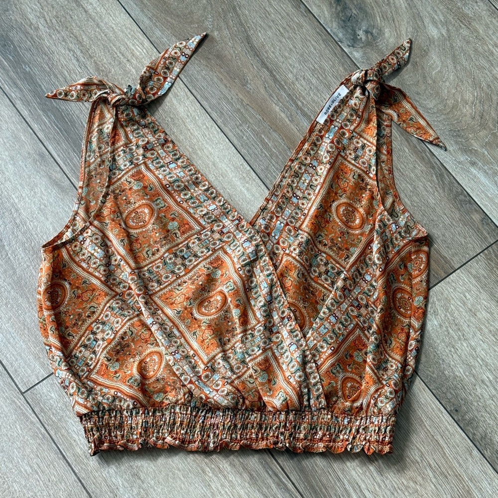 Lightweight and breezy cropped blouse featuring adjustable tie shoulders.